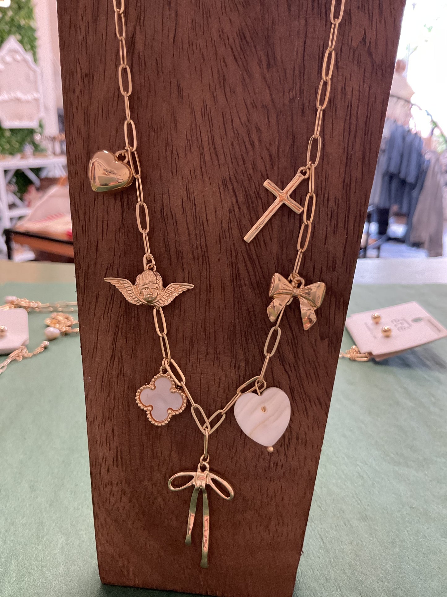 Gold charm necklace with bow/hearts/cross/clover