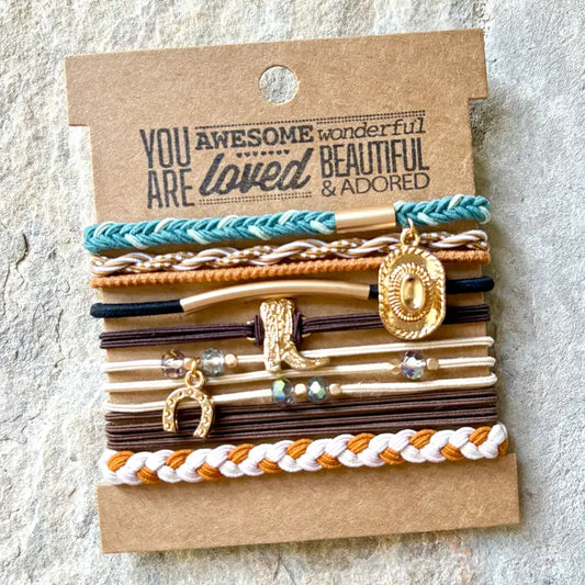 RUSTIC NEUATURAL BRAIDED HAIRTIE BRACLETS FEATURE A COWGIRL CHARM SET AGAINST AN ENCURAGING MESSAGE CARD