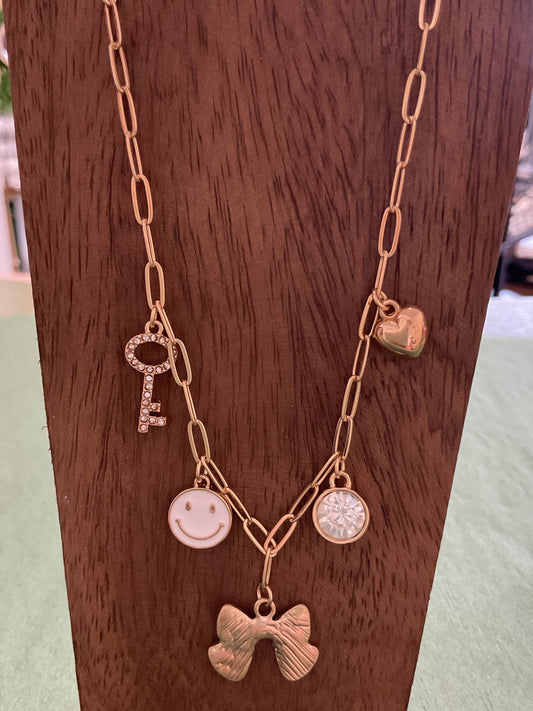 Gold charm necklace with bow and smile, smiley face
